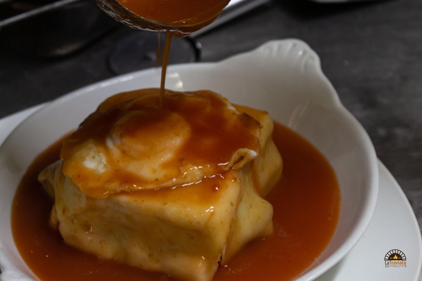 Francesinha com molho a ser vertido